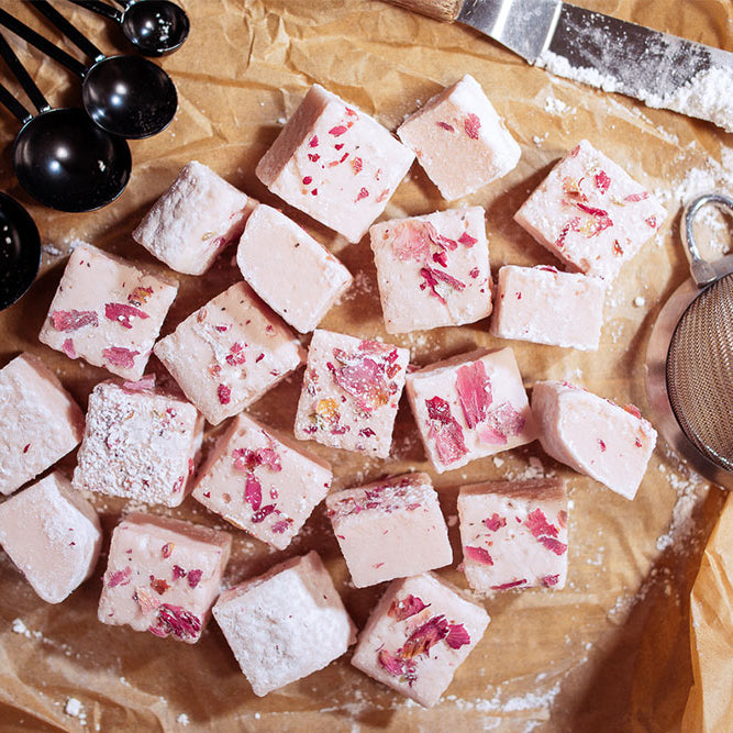 Photo of Vegan Rose Marshmallows with rose petals and powdered sugar.