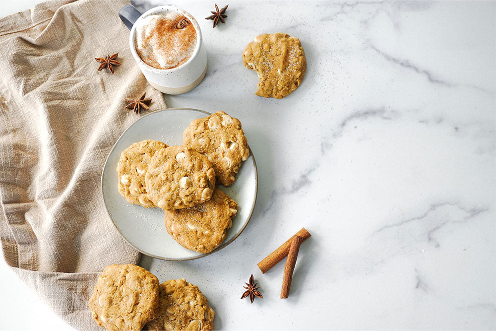 Photo of Brown Butter Pumpkin Spice White Chocolate Chip Cookies served with a foamy latte.