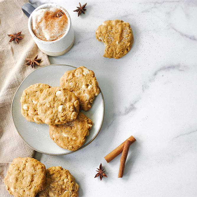 Photo of Brown Butter Pumpkin Spice White Chocolate Chip Cookies served with a foamy latte.