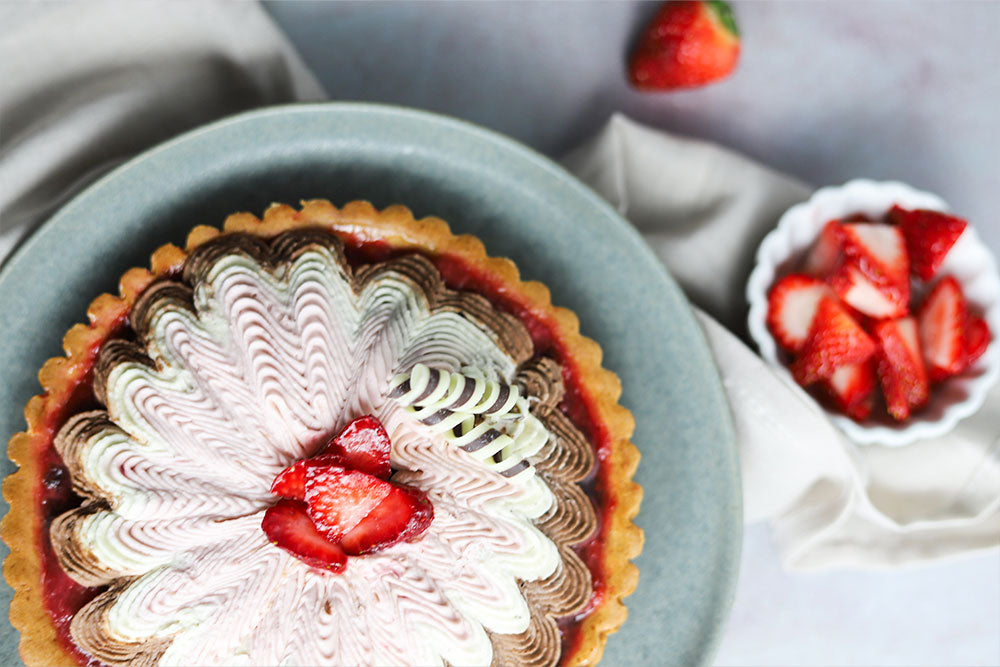 Image of a Neapolitan Tart garnished with chocolate décor and served with strawberry slices