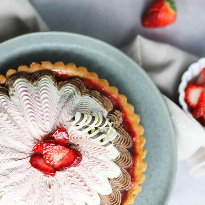 Image of a Neapolitan Tart garnished with chocolate décor and served with strawberry slices