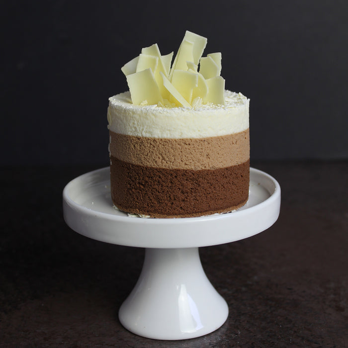 triple mousse cake topped with white chocolate shavings